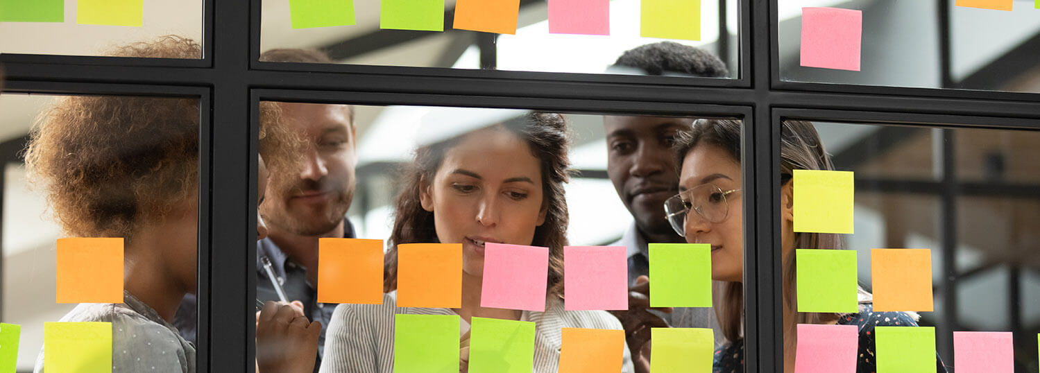 stock-photo-focused-young-diverse-teammates-working-with-caucasian-team-leader-on-it-startup-project-kanban-1563597499_uitsnede BRUG training en coaching in de zorg